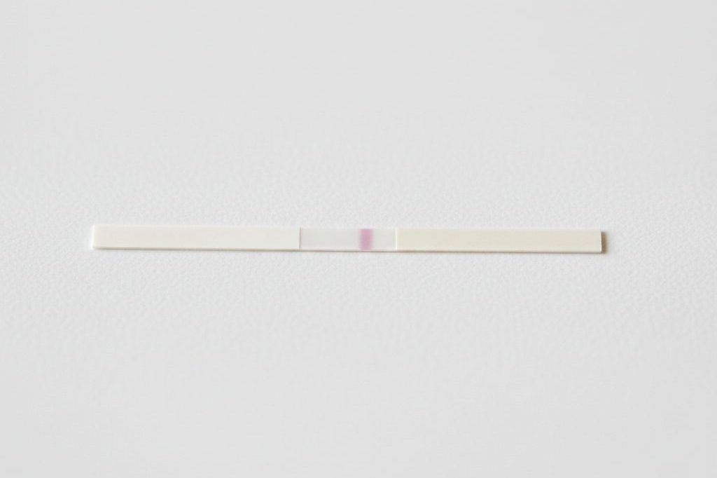 Immunoassay test strip showing a single control line on a clean white surface