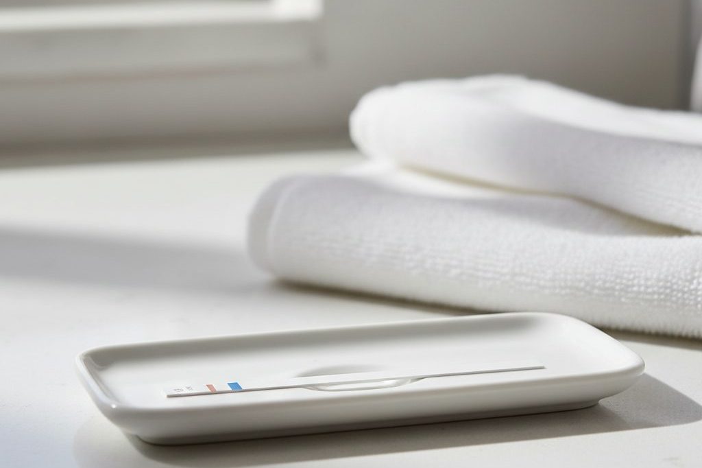 Plain home immunoassay test strip on a small tray on a bathroom counter